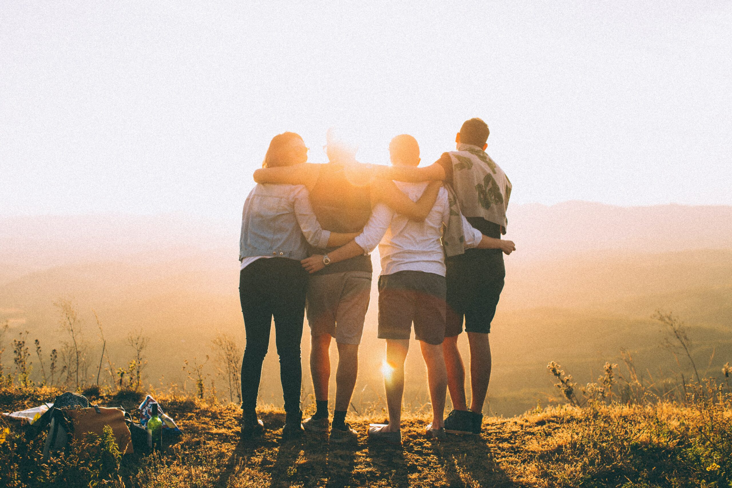 Amici che si abbracciano al tramonto