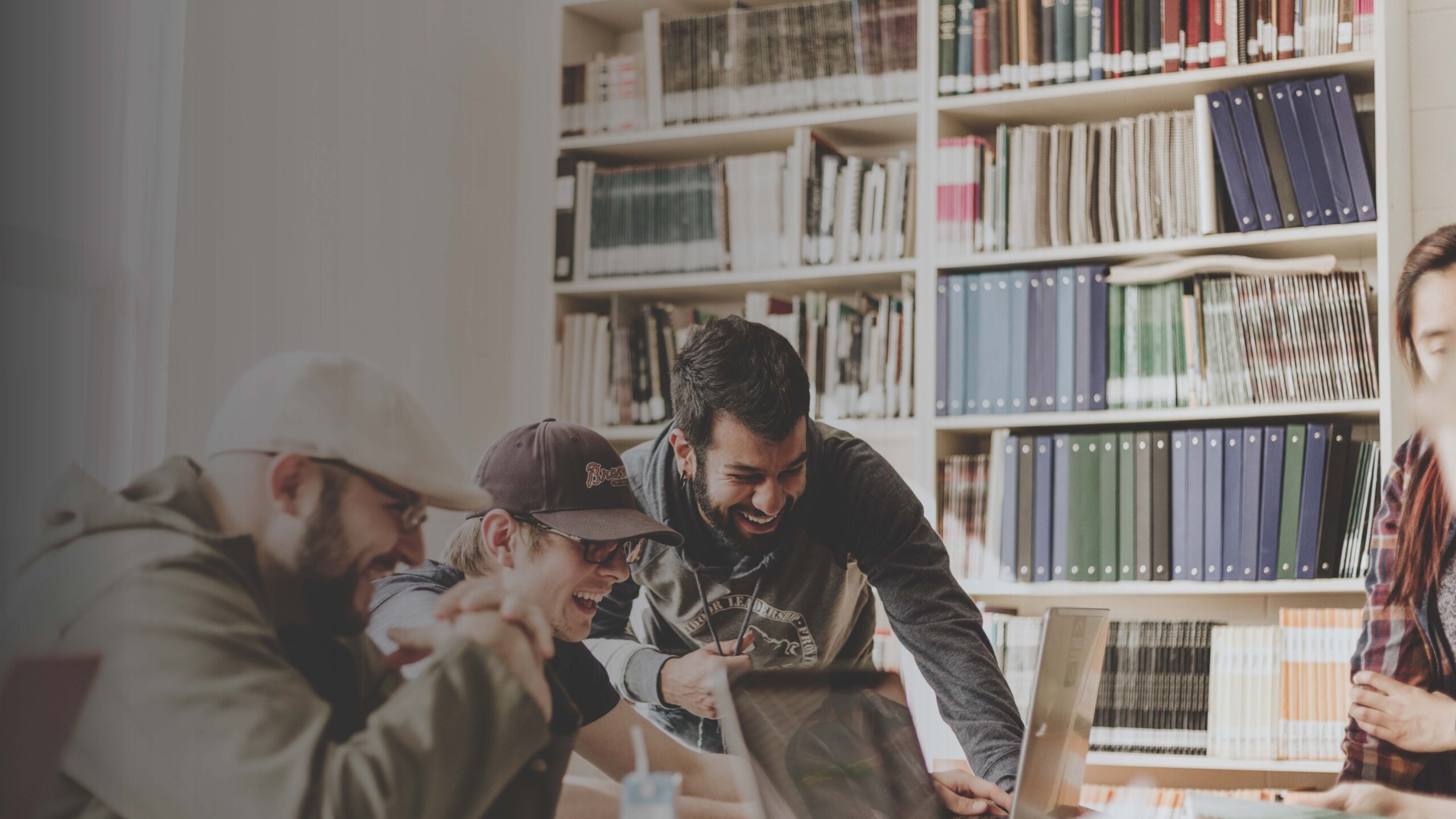 amici che ridono in biblioteca