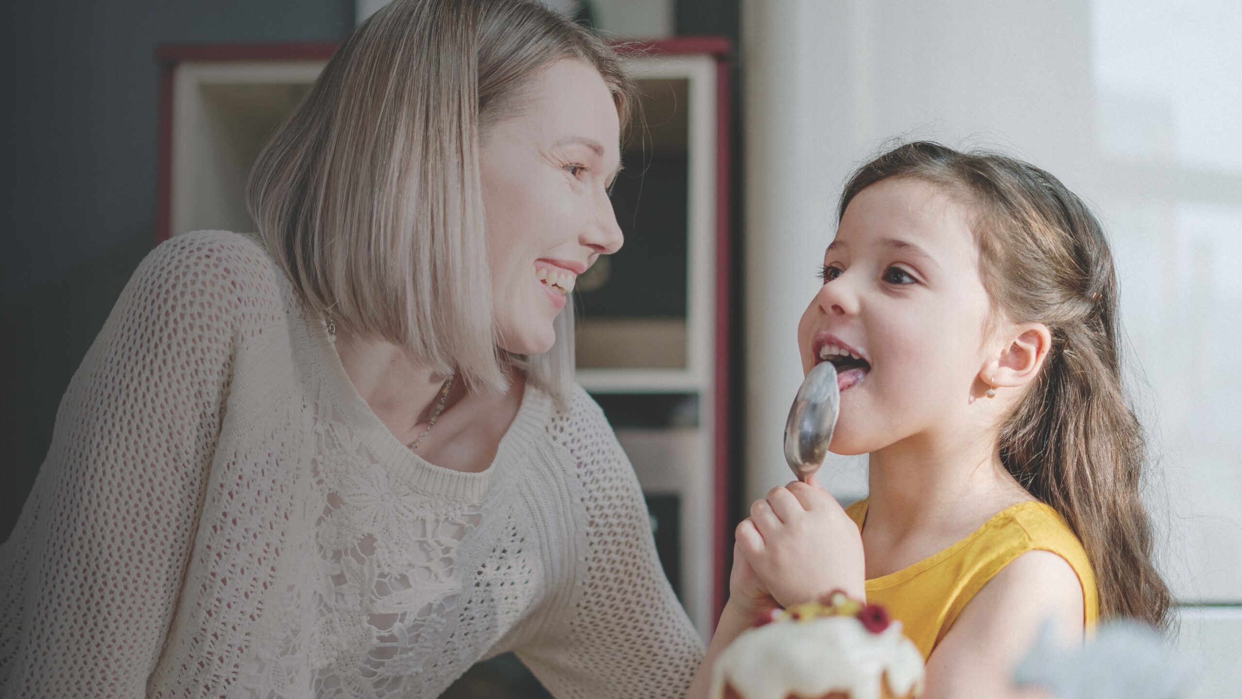 mamma e figlia mangiano dolce grigio