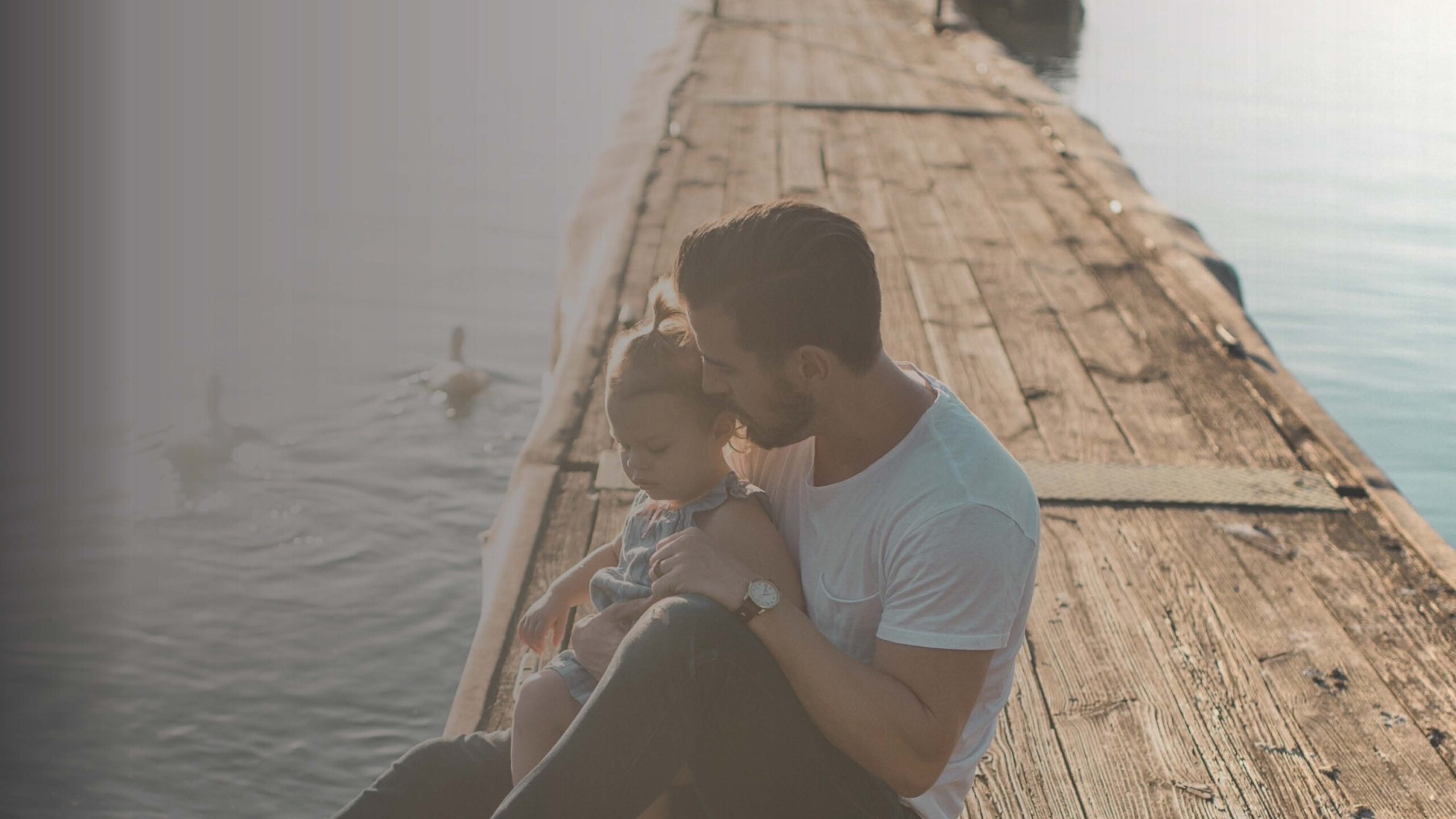 papà e figlia su pontile grigio