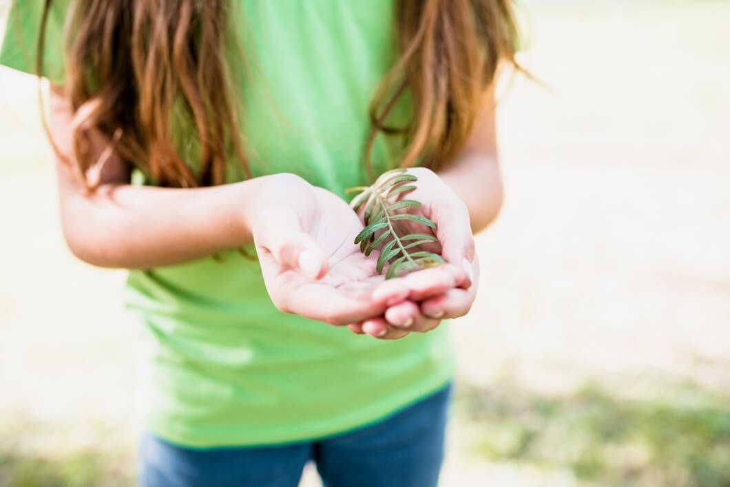 primo-piano-di-una-ragazza-in-verde-t-shirt-tenendo-il-ramoscello-nelle-mani